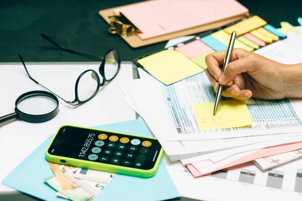 a person writing on yellow sticky note